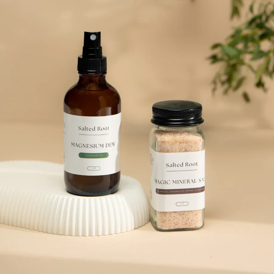 Salted Root wellness products — Magnesium Dew eucalyptus spray and Magic Mineral Salt — displayed on a neutral-toned background with soft lighting and natural greenery, creating a clean, calming, and earthy aesthetic.
